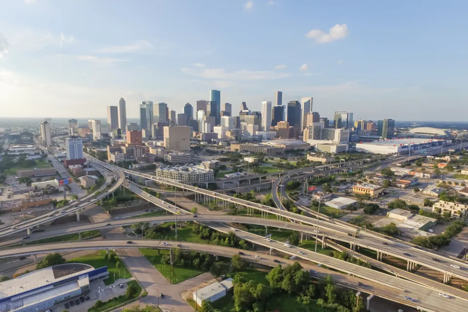 Aerial view of Houston freeway interchanges with downtown skyline in background